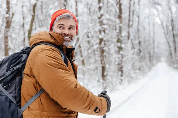 Walk with sticks. Man having a walk with scandinavian sticks in a snowy forest