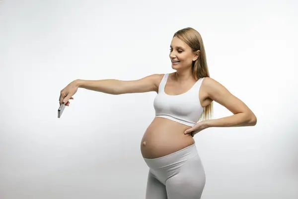 有电话的孕妇 手里拿着智能手机 头戴白色上衣的孕妇 — 图库照片