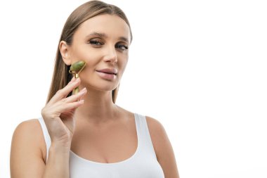 Yüz masajı. Sarışın kadın silindirle yüz masajı yapıyor.