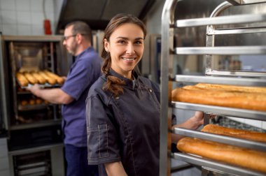 Pastanede Fransız ekmeği hazırlayan kadın ve erkek.