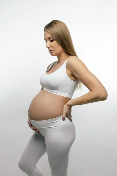怀孕了穿着白衣的漂亮的长发孕妇 — 图库照片