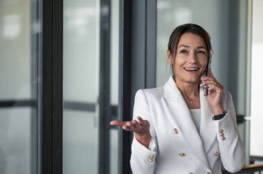 İş konuşmaları. Elinde telefon olan bir iş kadını portresi.