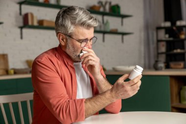 Hasta orta yaşlı adam grip belirtileri gösteriyor. İlaç şişesinde etiket var.