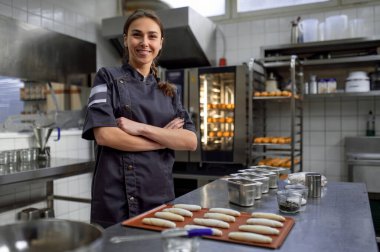 Kadın fırıncı profesyonel fırında kruvasan pişiriyor.