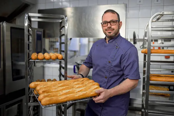 Tukang Roti Yang Tampan Memegang Baguettes Atas Nampan Dapur Toko — Stok Foto