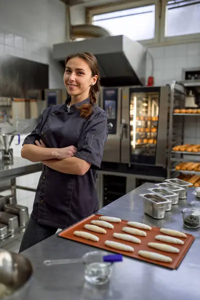 Woman baker producing classic croissants at bakery shop