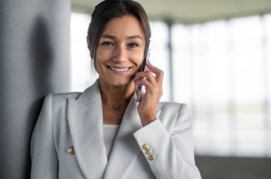 Modern iş kadını. Elinde telefon olan hoş, şık bir kadın.