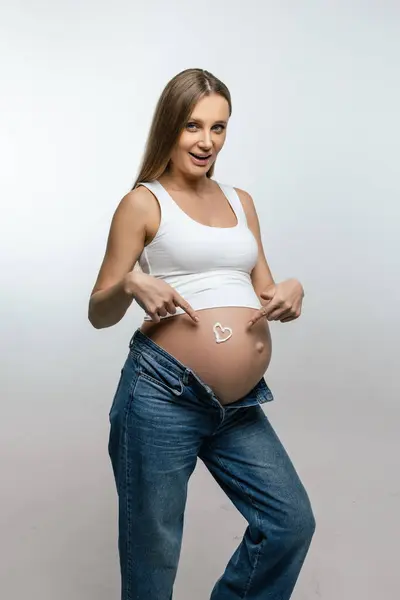 防拉伸霜 孕妇在肚子上涂了奶油 看上去很开心 — 图库照片