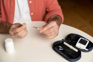 Evde oturan insülin şırıngalı tanınmayan diyabetik adam.