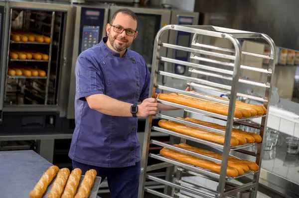 Seorang Tukang Roti Dengan Seragam Memanggang Baguette Dengan Rak Roti — Stok Foto