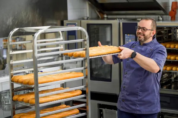 Man Bagare Enhetlig Bakning Baguetter Med Bröd Hyllor Bakgrunden Vid — Stockfoto