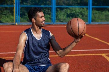 Yakışıklı basketbolcu dışarıda yaz sahasında antrenman yapıyor.