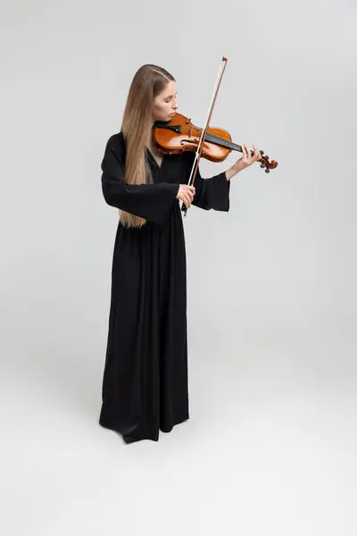 白い背景に隔離されたヴァイオリンを演奏する魅力的な女性ミュージシャンの全長の肖像画 ロイヤリティフリーのストック画像