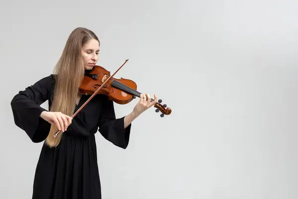 白い背景に隔離されたヴァイオリンを演奏する美しい若い女性 コピースペース ロイヤリティフリーのストック画像