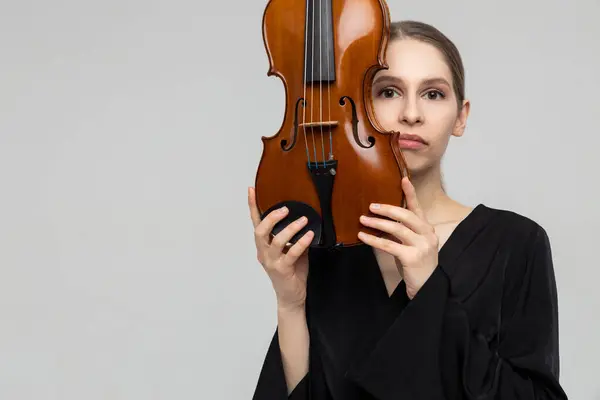 ヴァイオリンを保持する女性ミュージカルアーティスト 軽い灰色の背景 コピースペース ロイヤリティフリーのストック写真