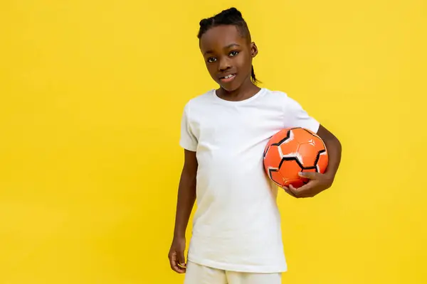 Αθλητικό Αφροαμερικανό Αγόρι Στολή Μπάλα Ποδοσφαίρου Απομονωμένη Πάνω Από Κίτρινο Εικόνα Αρχείου