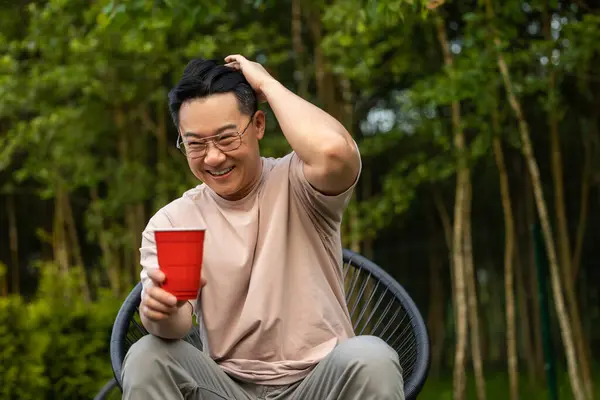 Glimlachende Man Zit Natuur Met Drank Uiten Vrolijke Uitdrukking Tijdens Rechtenvrije Stockfoto's