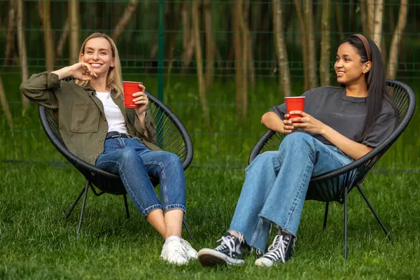 田舎で明るいピクニック過ごす週末を楽しんでいる多様な女性の友人 ストック画像