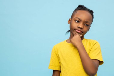 Ciddi çocuk. Sarı tişörtlü tatlı Afro-Amerikan çocuk ciddi görünüyor.