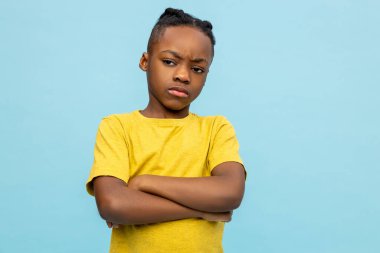 Huysuz çocuk. Sarı tişörtlü Afro-Amerikan çocuk huysuz görünüyor.