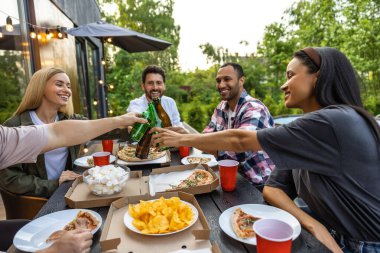Gençler dışarıda birlikte vakit geçirip dışarıda bira içerek eğleniyorlar.