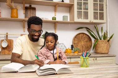 Genç baba, kızına ev ödevi yapmayı evde öğrendiğini anlatıyor.