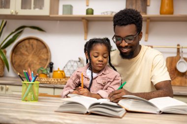 Genç baba, kızına ev ödevi yapmayı evde öğrendiğini anlatıyor.