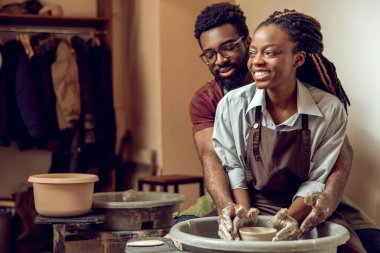 Yaradılış süreci. Çömlek çarkında birlikte çalışan mutlu bir çift.