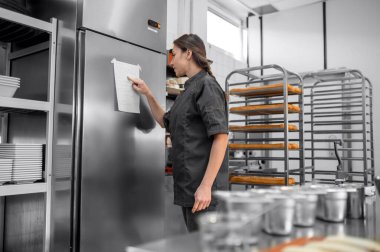 Üniformalı kadın restoran mutfağında çalışıyor.