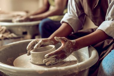 Şekil değiştiriyorum. Çömlek çarkındaki bir ürünün kalıbını çıkaran elleri kapatın.