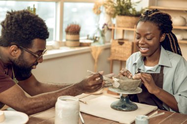 Çömlek kursu. Tatlı esmer kadın erkek bir heykeltıraşla çömlekçilik kursuna gidiyor.
