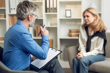 Mutsuz bir kadın danışmanlık ofisinde kanepede oturuyor ve erkek psikoloğa dertlerinden yakınıyor.