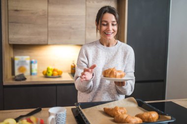 Kahvaltı vakti geldi. Kahvaltı hazırlayan ve memnun görünen hoş bir genç bayan.