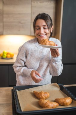 Kahvaltı vakti geldi. Kahvaltı hazırlayan ve memnun görünen hoş bir genç bayan.