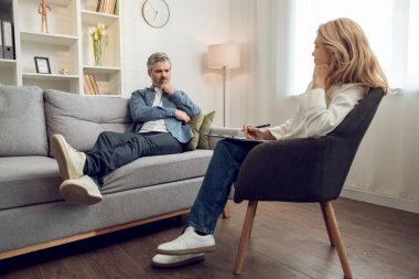 Kafkas kadın psikolog hastalarını dikkatle dinliyor. Modern rahat çalışma alanında tavsiye ve danışmanlık öneriyor..