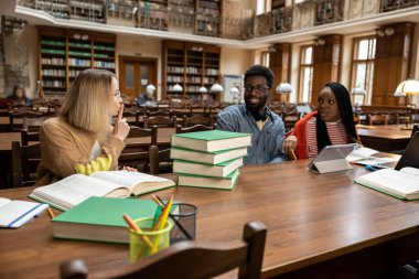 Dedikodular. Kütüphanede genç insanlar, telefonda konuşan sarışın bir kadın.