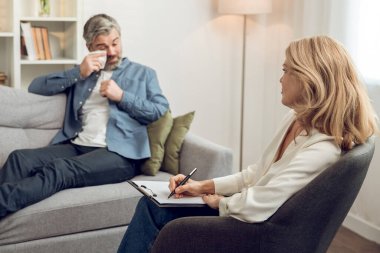 Kafkas kadın psikolog hastalarını dikkatle dinliyor. Modern rahat çalışma alanında tavsiye ve danışmanlık öneriyor..