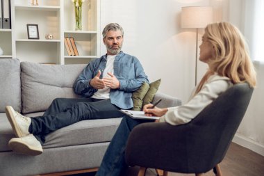 Kafkas kadın psikolog hastalarını dikkatle dinliyor. Modern rahat çalışma alanında tavsiye ve danışmanlık öneriyor..