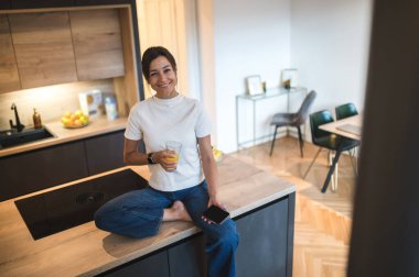 Bağlandı. Gülümseyen kadın evde vakit geçiriyor ve internette vakit geçiriyor.