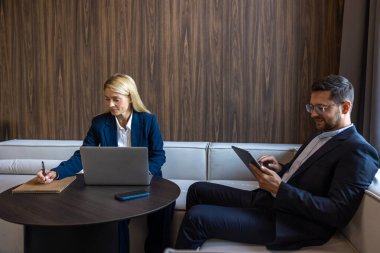 Dizüstü bilgisayar ve tablet üzerinde çalışan profesyonel iş arkadaşları yeni fikirleri tartışıyor.