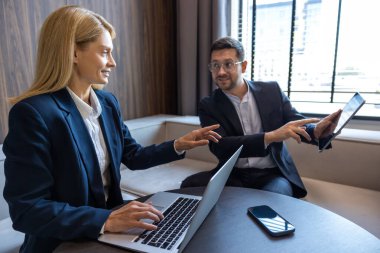 Ofisteki modern teknolojiyi kullanarak dijital projede çalışan kadın ve erkek.