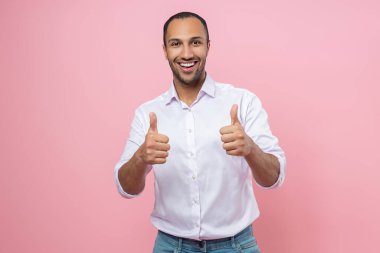 Beyaz gömlekli hoş bir adam pembe arka planda izole edilmiş bir jest gibi görünüyor.