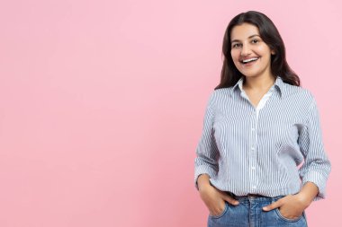 Gülümseyen Hintli kadın pembe arka planda izole edilmiş dişlek gülüşüyle kameraya bakıyor.