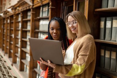 Çalışıyorum. Öğrenciler kütüphanede çalışıyor ve ilgili görünüyorlar.