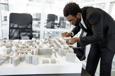 Çok çalışan melez mimar ofiste yeni dış tasarımlar tasarlıyor.