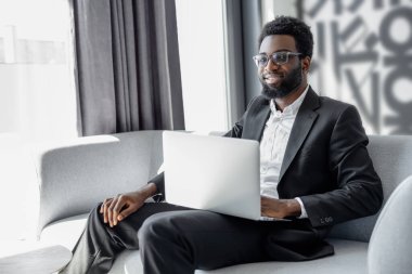 İş adamı. Başarılı ve kendinden emin bir Afro-Amerikan iş adamının laptoplu fotoğrafı.
