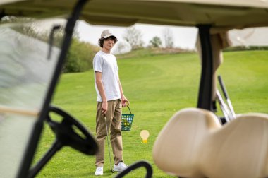 Bir golf kulübünde. Golf kulübünde şapkalı genç bir golfçü.