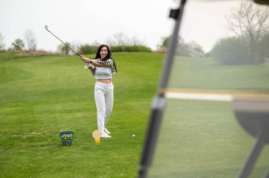 Neşeli beyaz kız golfçü yaz boyunca doğada golf oynuyor.