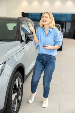 Yeni araba. Satıcıdaki sarışın güzel kadın mutlu ve heyecanlı görünüyor.