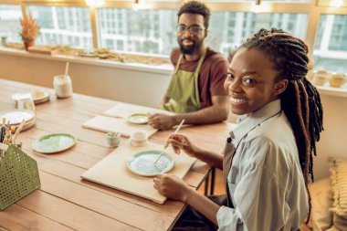 Atölye. Çömlek atölyesinde kille çalışan iki kişi.